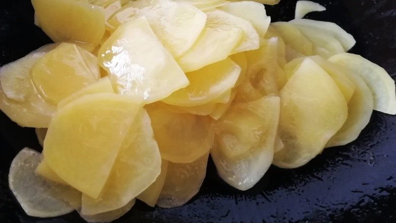 青椒土豆片,让每一片土豆片都包裹上油,文火翻炒一分钟。(水洗过的土豆片比较好熟)