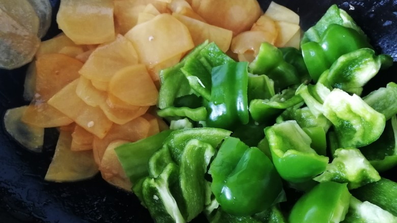 青椒土豆片,把土豆片推到一边,放入青椒,简单炒一下青椒。
