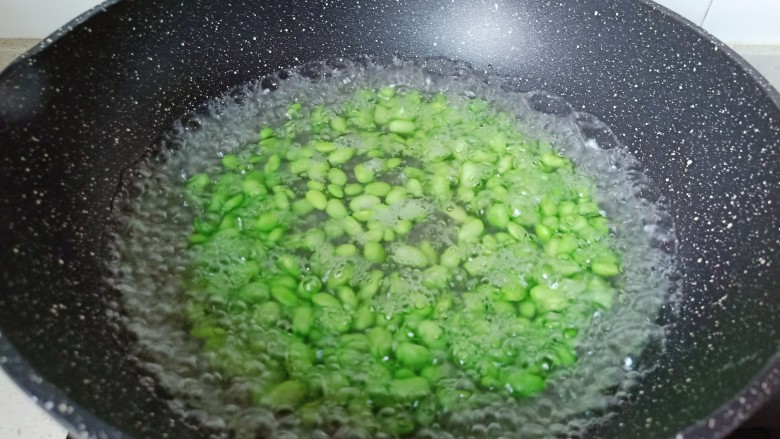 毛豆炒肉丝,要想炒好的毛豆颜色好看,加一点点的小苏打。焯水一分钟就可以捞出锅控水。