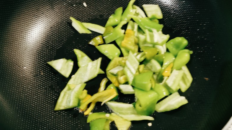 青椒土豆片,起油锅放入一汤匙食用油,放入青椒翻炒断生,盛出备用。