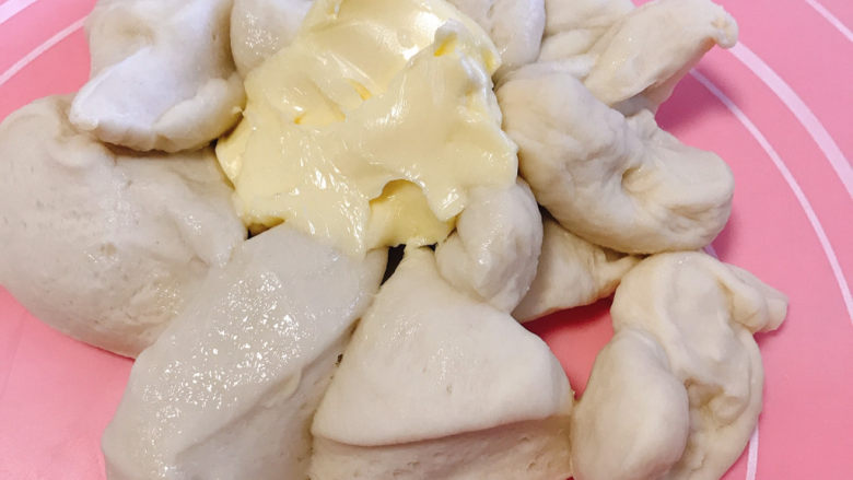酒浸蔓越莓软欧,6、将面团剪小块,加入室温软化的黄油,使面团与黄油完全融合,再不断的揉搓摔打