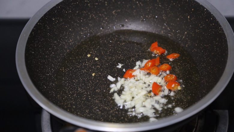 青椒土豆片,锅里烧热油,爆香蒜末和小米辣