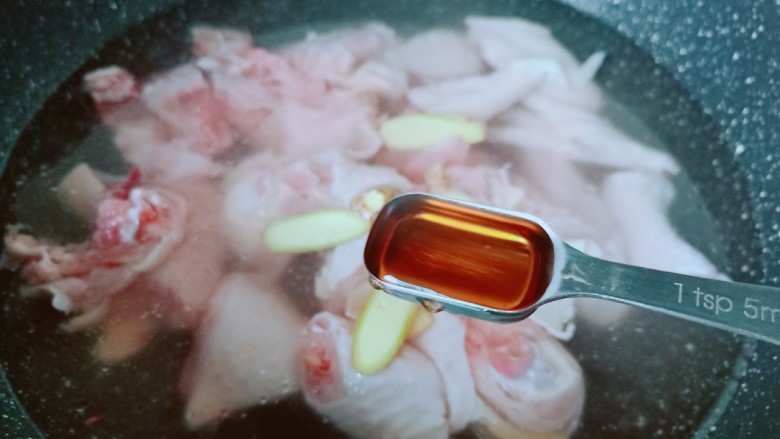 新疆大盘鸡,鸡块冷水下锅,加生姜片与料酒焯下水去腥。