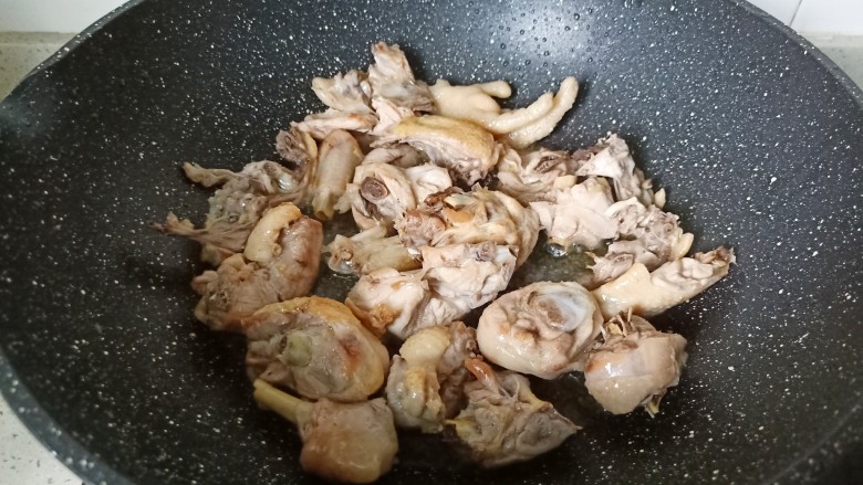 新疆大盘鸡,翻炒到鸡块表面微黄,炒出鸡肉当中的油脂,放适量姜蒜翻炒。
