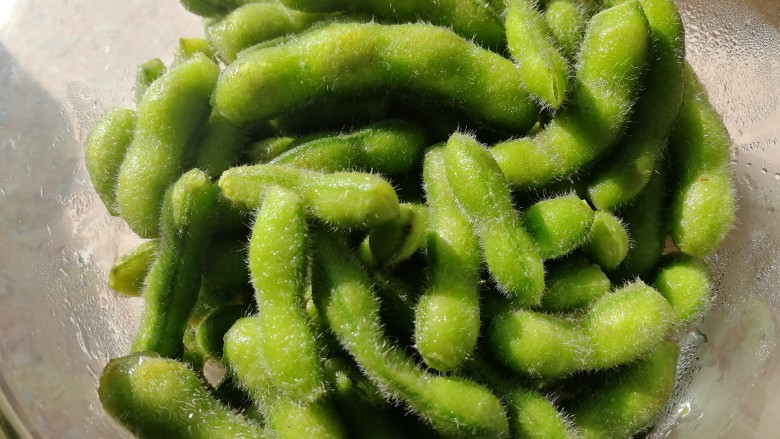 毛豆炒肉丝,带皮毛豆,洗净开水焯一分钟。