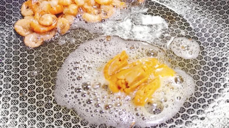 耳光炒饭,然后将河虾推至锅边,将鸭蛋黄炒香