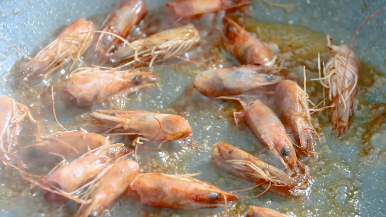 耳光炒饭,起锅热油,油热后放入虾头,炒出红色的虾油