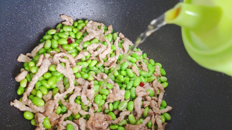毛豆炒肉丝,加适量料酒,翻炒均匀