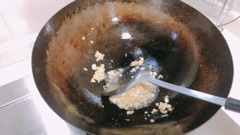 红烧鱼块,锅内热油,放入蒜末和姜末爆香。