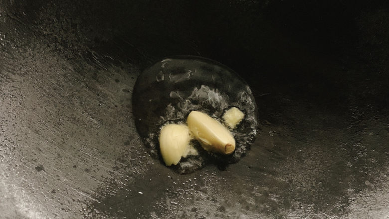 糖醋包菜,锅烧热油,加入拍碎的蒜瓣爆香。