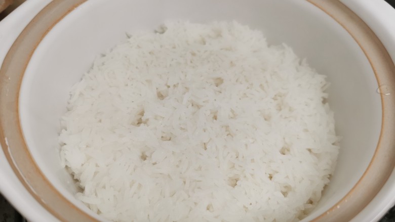 广式煲仔饭,放肉肉之前,绕着饭与煲接触边,轻轻的浇一圈花生油(注意别重手了,控制油量),这样做,焗出的煲仔饭,饭焦香脆。