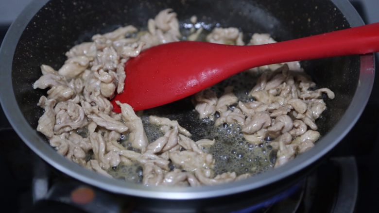 毛豆炒肉丝,锅里烧热油,下肉丝炒至变色