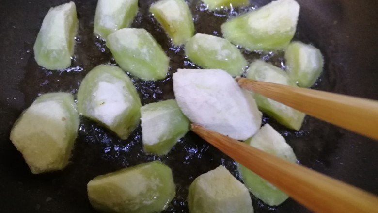 糖醋茄子,油五成热放入茄子,文火煎炸。