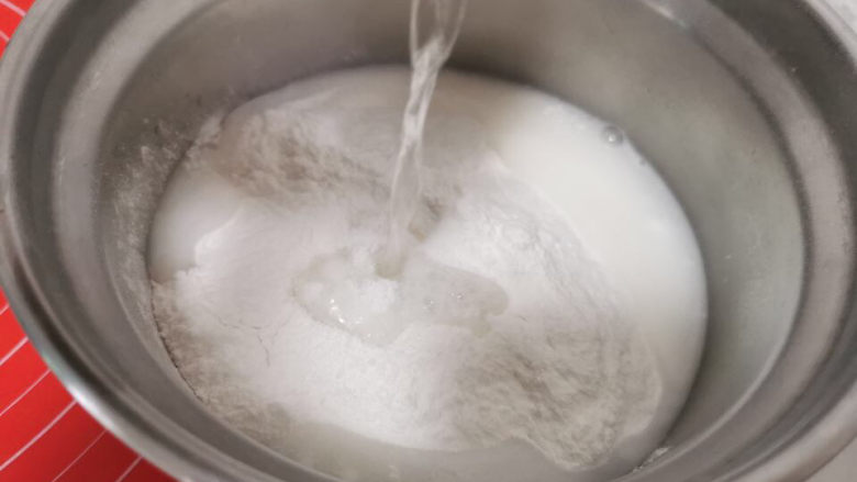 绿豆南瓜子冰皮月饼,冰皮月饼预拌粉倒入盆中,加入85度热水