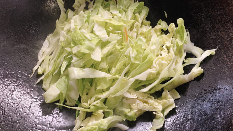 包菜炒粉丝,加入包菜丝,点些清水焖炒。