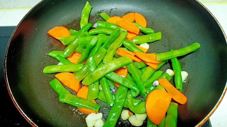 清炒山豆角,倒入山豆角和胡萝卜片