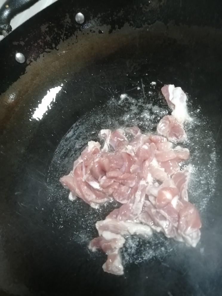 毛豆炒肉丝,开火加热锅,倒入油,倒下瘦肉丝翻炒大概2分钟