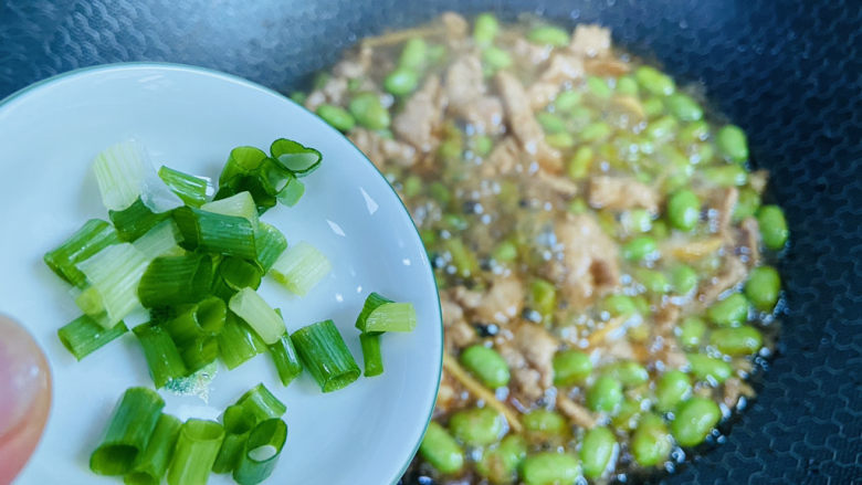 毛豆炒肉丝,入葱花翻炒均匀即可食用