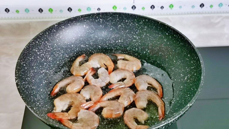 麻辣虾尾,起油锅,先加入虾尾小火煎。