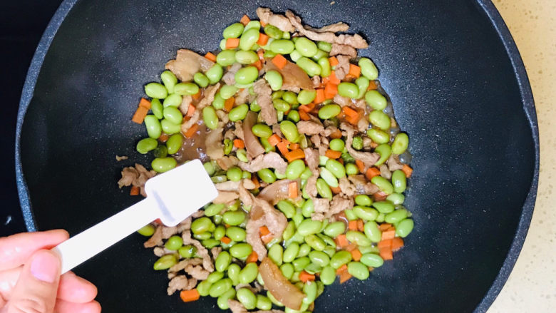 毛豆炒肉丝,炒至八成熟后,撒入少许盐调味