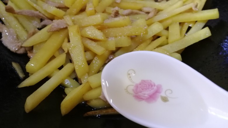 土豆炒肉丝,加3勺清水,让盐更好的入味,文火炒让土豆条熟透。