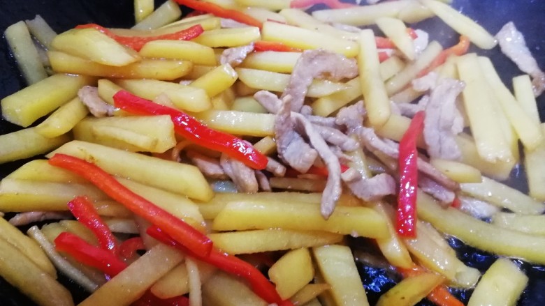 土豆炒肉丝,放入红椒丝,文火翻炒均匀。
