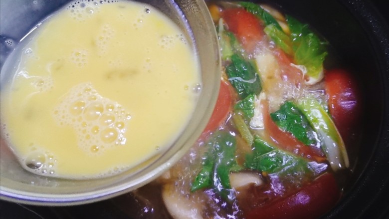 西红柿香菇汤,煮开后,将鸡蛋液淋入汤锅中