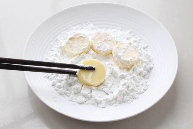 红烧日本豆腐,盘中倒入20克玉米淀粉,将日本豆腐放进去薄薄的裹上一层淀粉。