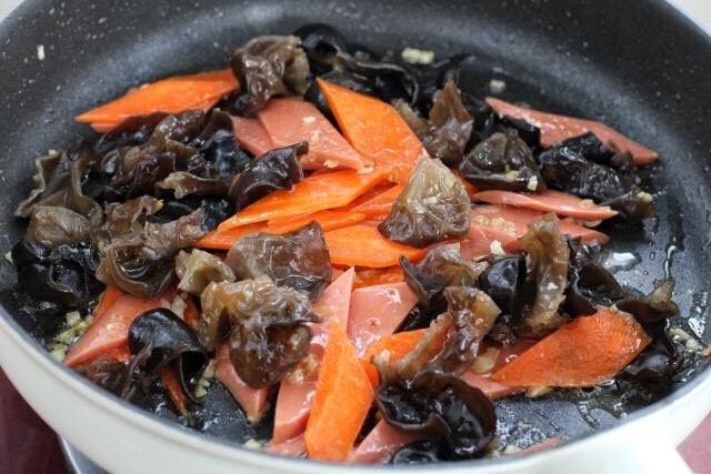 红烧日本豆腐,接着放入胡萝卜和黑木耳,改大火快速翻炒至木耳噼啪作响。