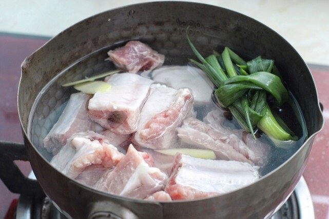 排骨豆角焖面,将排骨冷水下锅,放入葱结和一半的姜片,煮至沸腾撇去表面浮沫,捞出排骨沥干水分。