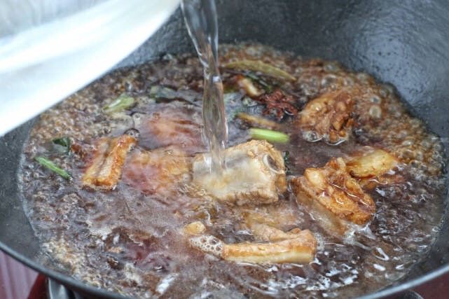 排骨豆角焖面,倒入热水煮沸后改小火,加盖焖煮二十分钟。