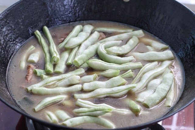 排骨豆角焖面,然后舀出一碗汤汁备用,把豆角放进去继续焖炖十分钟。