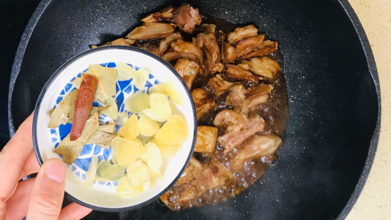 红烧羊排,看见颜色到位后,加入大蒜片和香料