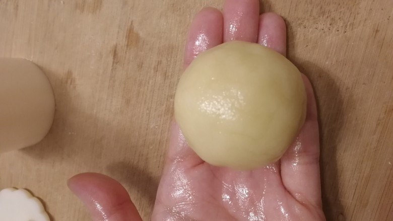 五仁月饼,面剂按扁,放入馅料,皮薄馅多,虎口慢慢收紧封口。