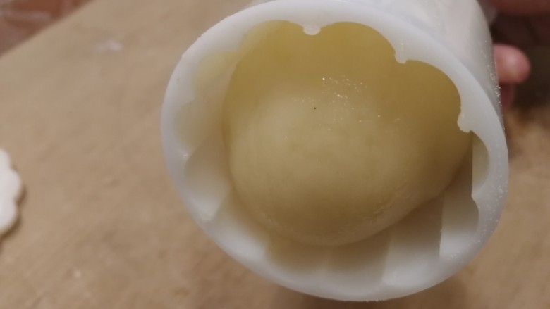 五仁月饼,稍微搓成椭圆形,放入涂了糕粉的模具里。