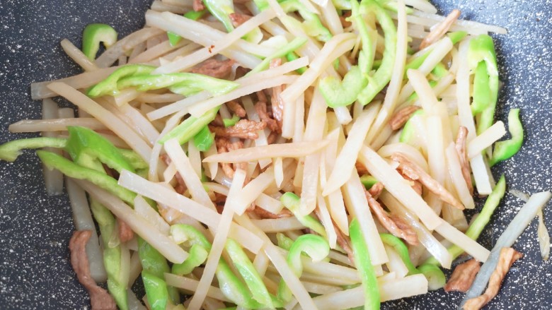 土豆炒肉丝,下入青椒,翻炒至断生。