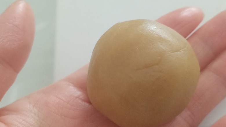 蛋黄莲蓉月饼,包好后收口朝下放置,把剩余的10个也包好。蛋黄莲蓉馅就做好了,保证每个馅共30克