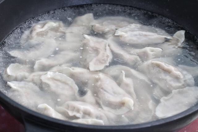 猪肉白菜水饺,将所有的饺子包好就可以下锅煮了,锅中添足够量的清水大火烧至沸腾,下入饺子用笊篱擦着锅底轻轻推动饺子,煮五、六分钟后饺子漂浮在水面上,饺子皮涨鼓就差不多熟了,捞入盘中即可。