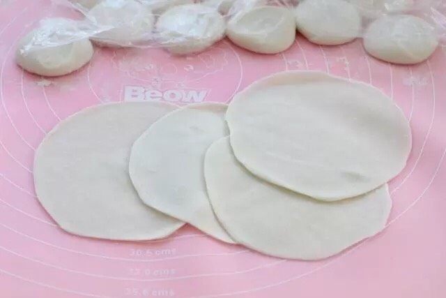 三鲜蒸饺,用擀面杖擀成薄薄的饼皮,中间要相对于边缘厚一些,不操作的面团覆盖保鲜膜防止风干。