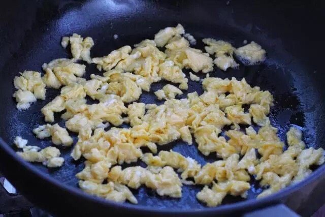 三鲜蒸饺,锅中加入适量食用油烧热,鸡蛋打散倒入锅中,凝固后翻炒捣成小块,盛出晾凉备用。
