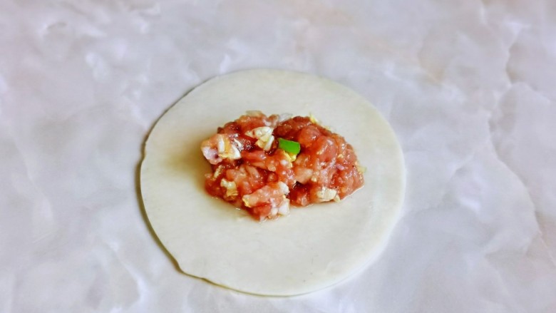 猪肉白菜水饺,取一张<a style='color:red;display:inline-block;' href='/shicai/ 4346'>饺子皮</a>,放上适当的馅料,根据个人喜欢包起来即可。
