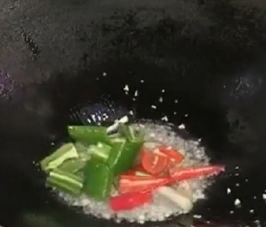 茭白炒腊肉,然后起锅倒油,油热倒入蒜末。姜片,葱白翻炒一会然后再倒入青椒,红椒翻炒一会出香味