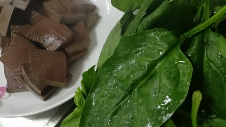 鸭血炒菠菜,捞出鸭血控水,菠菜去根洗干净。