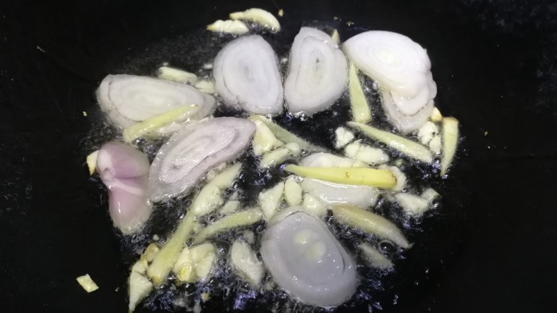 鸭血炒菠菜,热锅凉油,油微热放入圆葱片,姜丝,蒜末,文火炒香。
