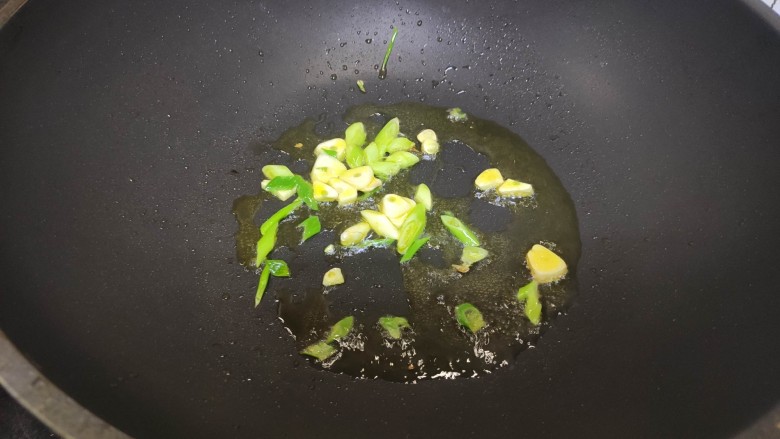 红烧土豆,加入葱花蒜片,炒香