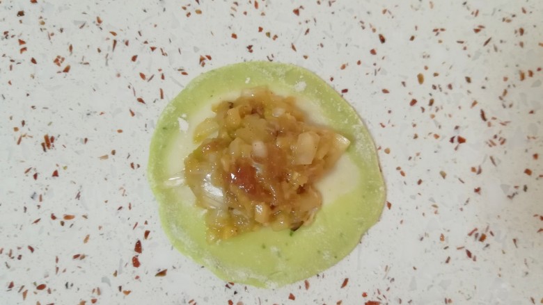 猪肉白菜水饺,取一个擀好的饺子皮放上馅。