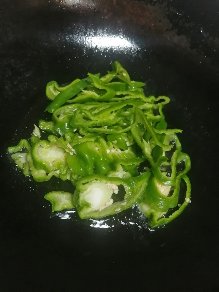 青椒皮蛋,开火加热锅倒入油,加青椒翻炒大概2分钟。