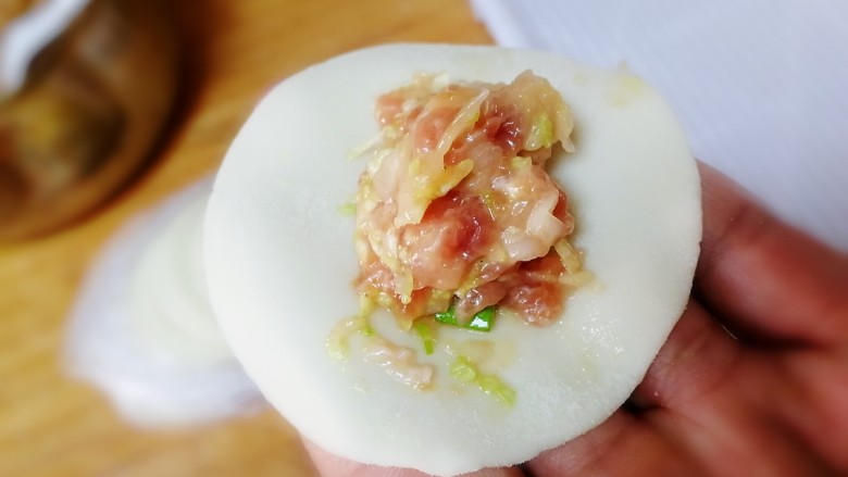 猪肉白菜水饺,取一个<a style='color:red;display:inline-block;' href='/shicai/ 4346'>饺子皮</a>,适量肉馅放在中间,先捏中间,在捏两边,捏紧。(这个时候烧水)