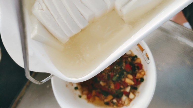 皮蛋豆腐,这是最重要的一步,蒸过的豆腐,会出现水分,把豆腐的水分倒入调料碗中,并和调料搅拌均匀