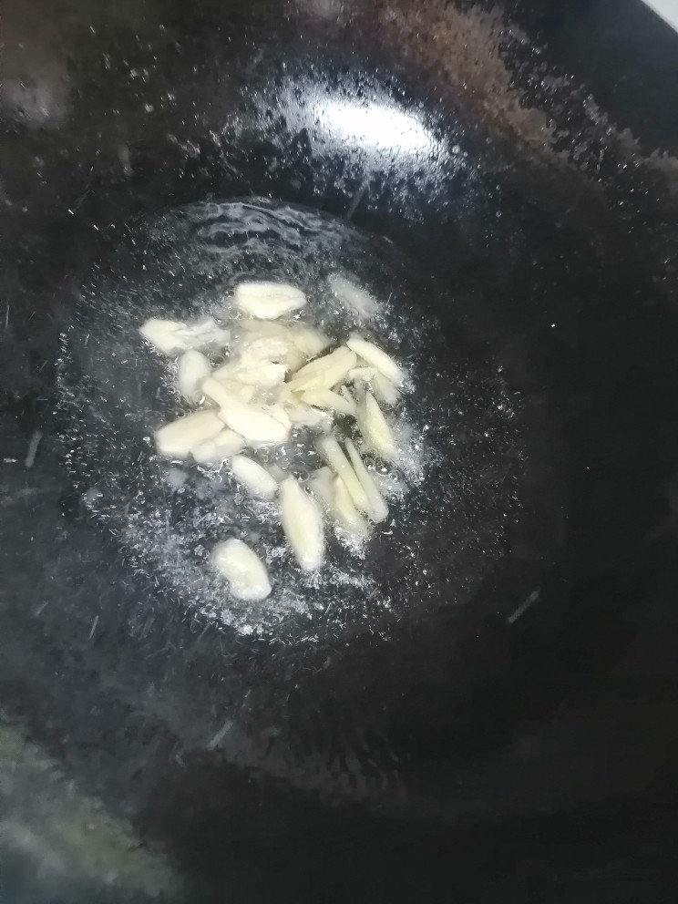 鸭血炒菠菜,开火加热锅倒入油,倒入姜蒜炒香。